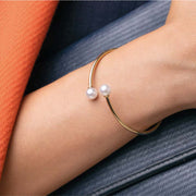 Bracciale rigido dorato con perle bianche