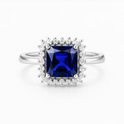 Anello in argento con pietra blu e doppia cornice di zirconi